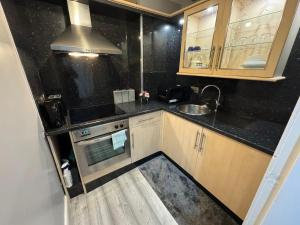 a small kitchen with a sink and a stove at Stylish Glasgow Apartment in Whiteinch