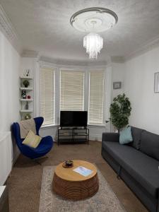 a living room with a couch and a table at Stylish Glasgow Apartment in Whiteinch