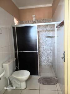 a bathroom with a toilet and a shower with a glass door at Apartamento Aconchegante 1 quarto in Crato
