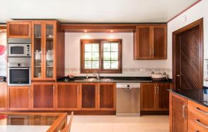 a large kitchen with wooden cabinets and a window at Montelago in Alcudia +39 photos