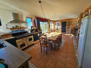 a kitchen with a table and chairs in a kitchen at Ferme écologique in Saint-Junien-les-Combes