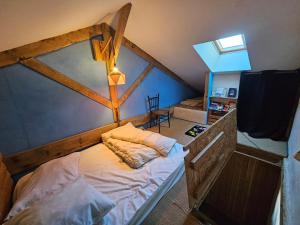 an attic bedroom with a bed in a room at Ferme écologique in Saint-Junien-les-Combes