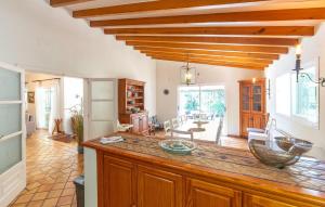a kitchen with a counter top and a living room at Casa Maria in Santa Maria del Camí