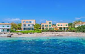 a row of houses on an island in the water at Sa Copinya in Cala Bona +26 photos