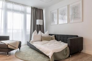 a bed in a living room with a couch at Sea la Vie - Seitlicher Meerblick zwischen Südstrand und Yachthafen in Fehmarn