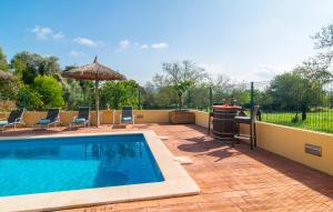 a swimming pool with chairs and an umbrella at Ca Na Conceda in Alcudia