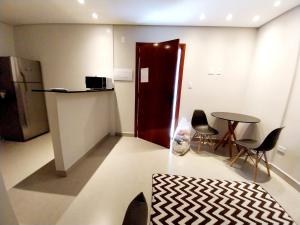 a room with a counter and a table and chairs at Prime Flat Palladium Mar & Piscina in São Vicente