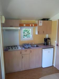 a small kitchen with a sink and a stove at ZEcamping 3 étoiles chiens acceptés piscine en bord de rivière avec Canoë in Mazères