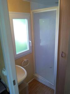 a bathroom with a sink and a glass shower door at ZEcamping 3 étoiles chiens acceptés piscine en bord de rivière avec Canoë in Mazères