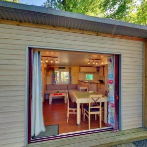 a large sliding glass door on a patio with a table at ZEcamping 3 étoiles aire de jeux multi-activités in Toulouse