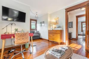a living room with a couch and a tv on the wall at Boscobel Bungalow in Nashville +23 photos