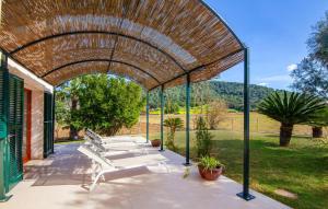 a pergola with white benches on a patio at Sa Mina De Crestatx in Sa Pobla