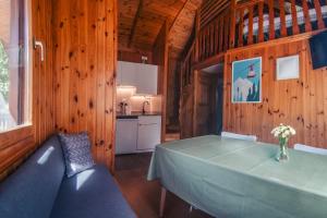 ein Esszimmer mit einem Tisch und einer Küche in der Unterkunft Camping Boneta in Barruera