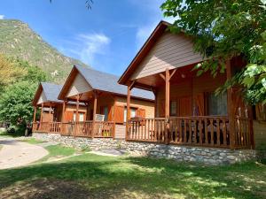 eine Blockhütte mit Veranda und Terrasse in der Unterkunft Camping Boneta in Barruera
