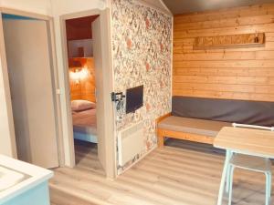 a small room with a bench and a bed at ZEcamping 3 étoiles Aveyron - Espace aquatique calme et nature in Montlaur