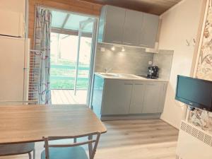a kitchen with a wooden table and a kitchen with a window at ZEcamping 3 étoiles Aveyron - Espace aquatique calme et nature in Montlaur