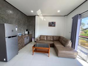 a living room with a couch and a refrigerator at 365 Place Maikhao in Ban Mai Salae