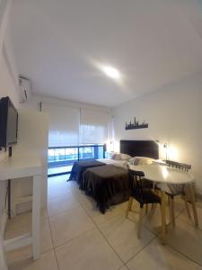 a bedroom with a bed and a table and a desk at Osiris Plaza in Buenos Aires