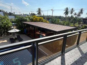 a balcony with a building with a table and chairs at 365 Place Maikhao in Ban Mai Salae