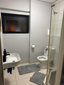 a small bathroom with a sink and a toilet at 51 Lazarett Loft & Car Rental in Windhoek +14 photos