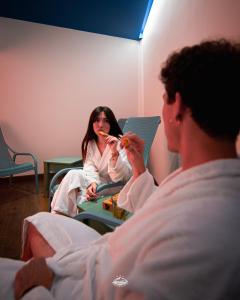a woman eating food in a room with a man at Albergo Parco Gran Sasso in Castel del Monte