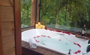a bath tub in a room with a window at Refúgio Bocaina in Bocaina do Sul