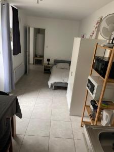 a bedroom with a bed and a tiled floor at L'Abbatiale in Néris-les-Bains