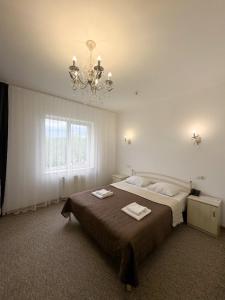 a bedroom with a large bed and a chandelier at Маєток Сокільське in Tyudov +36 photos