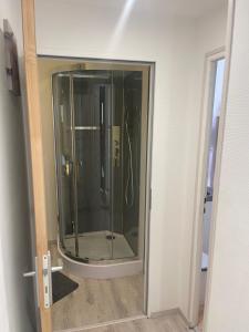 a glass shower in a room with a door at L'Abbatiale in Néris-les-Bains