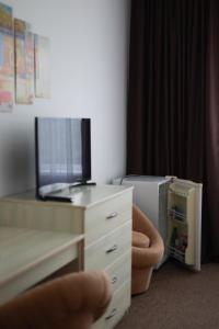 a hand is pointing at a dresser with a tv at Маєток Сокільське in Tyudov