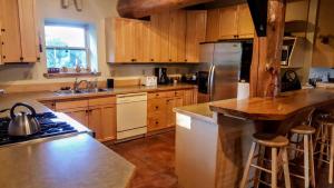 a kitchen with wooden cabinets and stainless steel appliances at Spectacular Large Group Accommodations With Gallatin River Access! in Bozeman