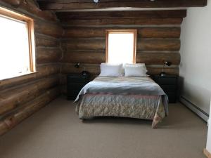 a bedroom with a bed in a log cabin at Spectacular Large Group Accommodations With Gallatin River Access! in Bozeman