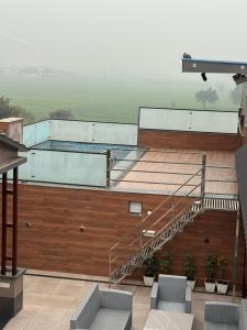a swimming pool on top of a building with a staircase at Nurem Hotel and Resort in Lalru