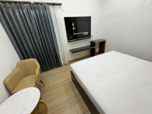 a room with a bed and a tv and a chair at Nurem Hotel and Resort in Lalru