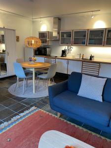 a living room with a blue couch and a table at Carlsminde ferielejlighed in Stenstrup +15 photos