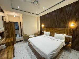a bedroom with a large bed with a wooden headboard at Nurem Hotel and Resort in Lalru +26 photos