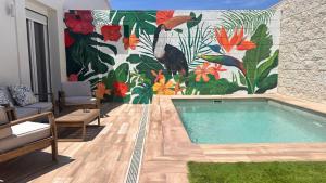 a swimming pool in a room with a mural at Huellas de la Mancha in Burguillos de Toledo