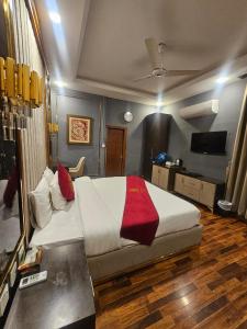 a bedroom with a large bed and a television at Ambassador Suites in Dargai