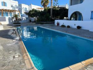 a swimming pool with blue water in front of a house at Home sea home in Agios Ioannis