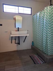 a bathroom with a sink and a mirror at Coco Beach House in Coco