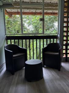 two chairs and a table in front of a window at Cozy cocoon in La Madeleine in Cayenne