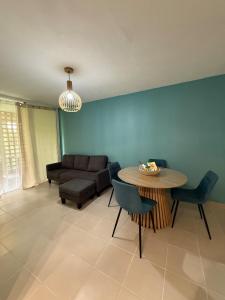 a living room with a table and a couch at Cozy cocoon in La Madeleine in Cayenne