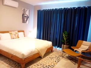a bedroom with a bed and blue curtains at Mills Pad with 2-bedroom in Nelspruit +10 photos