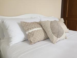 a bed with four pillows on it at Locanda Rabaya' in Barbaresco
