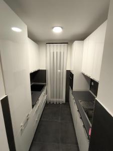 a small kitchen with white cabinets and a sink at Veneto Apartment in Prishtinë