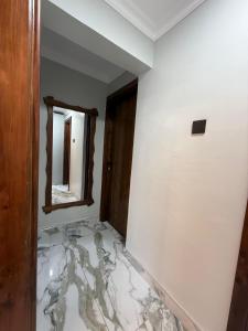 a room with a marble floor and a mirror at Sage Homes in Nairobi