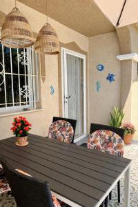 a black table and chairs in a patio with windows at Casa Moolio - Private Holiday Home with Pool Access, Walk to Beach & Restaurants in Los Alcázares