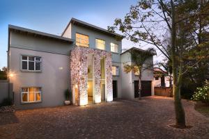 a house with a driveway in front of it at Sandown Guest House in Johannesburg