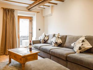 a living room with a couch and a coffee table at Wheelwright Cottage in Clunbury