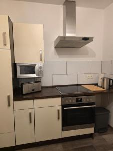 a kitchen with a stove and a microwave at Naturnest Berzbuir in Düren - Eifel +5 photos